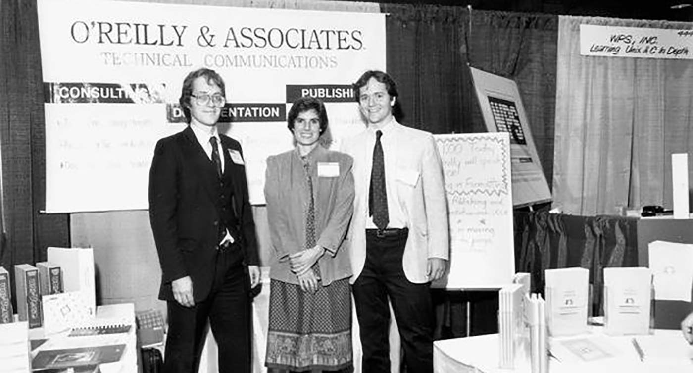 Tim O'Reilly, Nancy Dougherty, and Dale Dougherty, in 1985 or so, ready to sell some of O'Reilly's first books (over on the right) to customers.